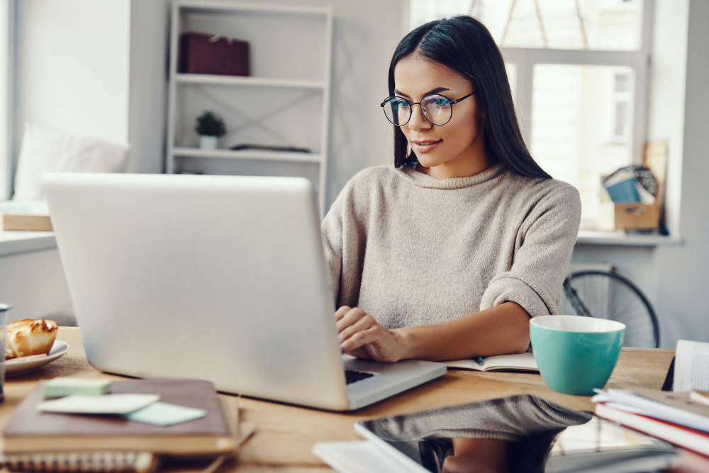 Mujer en su escritorio buscando las mejores opciones para un software de facturación electronica